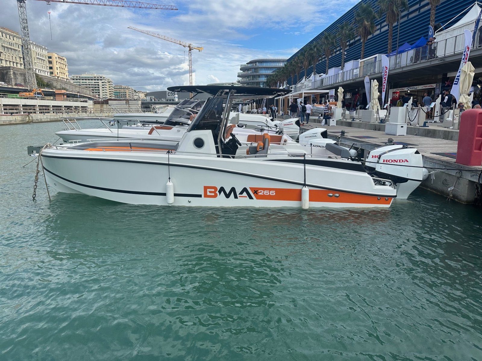 BMA X266 vue latérale au port — profil complet coque blanche et orange bimoteur Honda