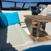 Parker 780 Escape banquette cockpit grand angle avec table teck et coussins turquoise Parker 780 Escape banquette cockpit grand angle avec table teck et coussins turquoise